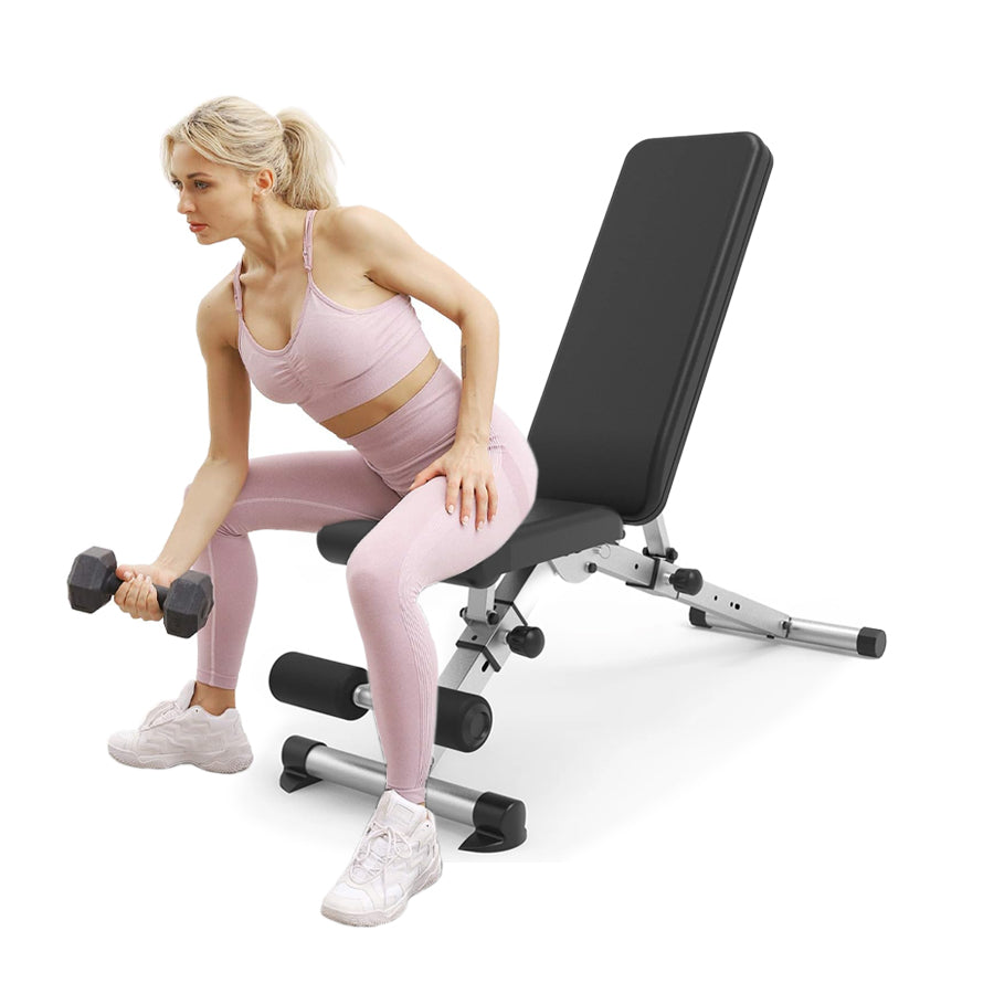 Woman exercising with dumbbells on a weight bench against a white background