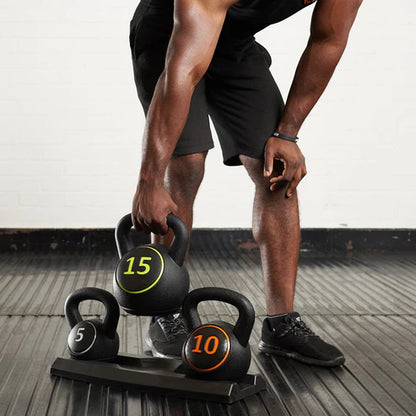 Person lifting kettlebells on a wooden floor with a white wall background