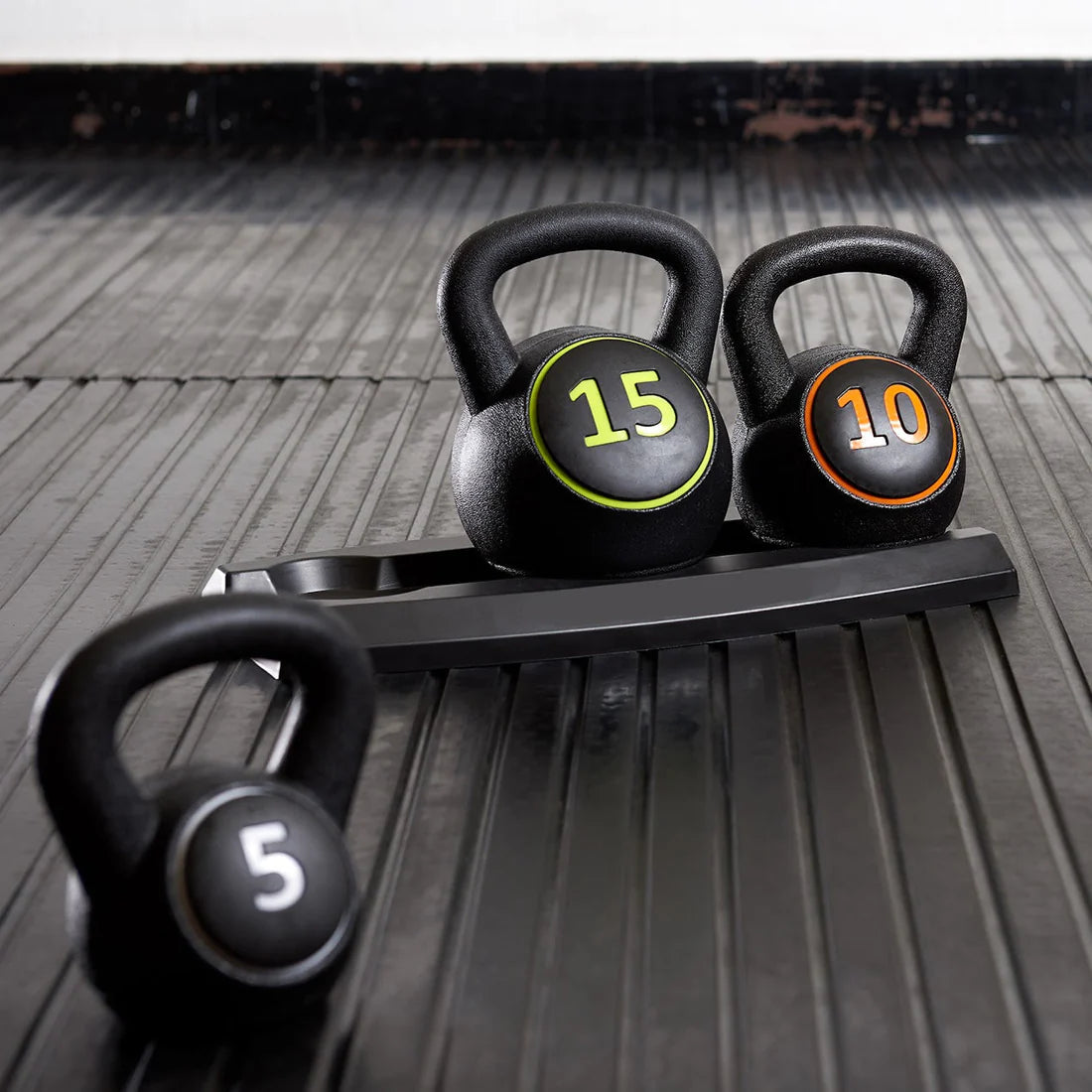 Three kettlebells with weights on a wooden floor