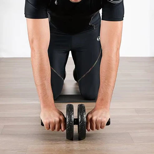 Person using an ab roller on a wooden floor