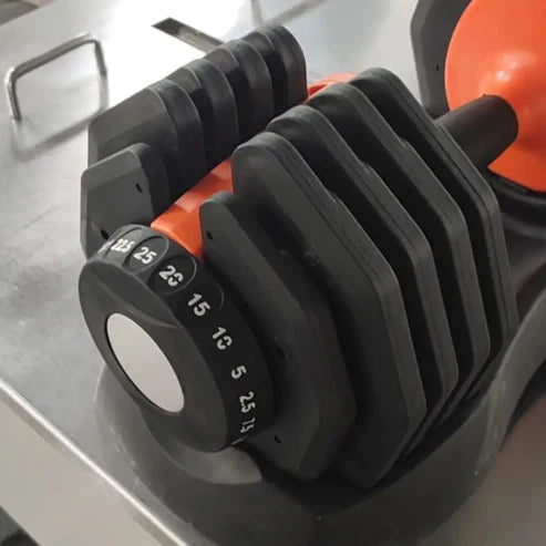 Black adjustable dumbbell on a metallic surface