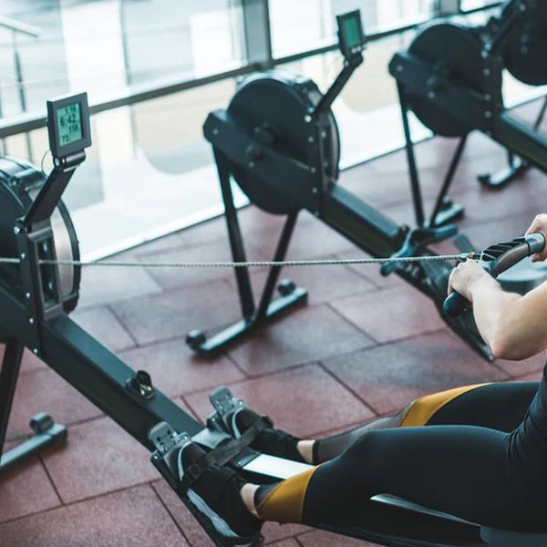 Person using a rowing machine in a gym setting
