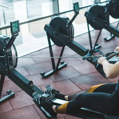 Person using a rowing machine in a gym setting