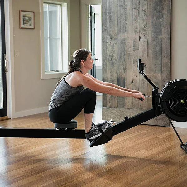 Woman using a rowing machine in a home setting
