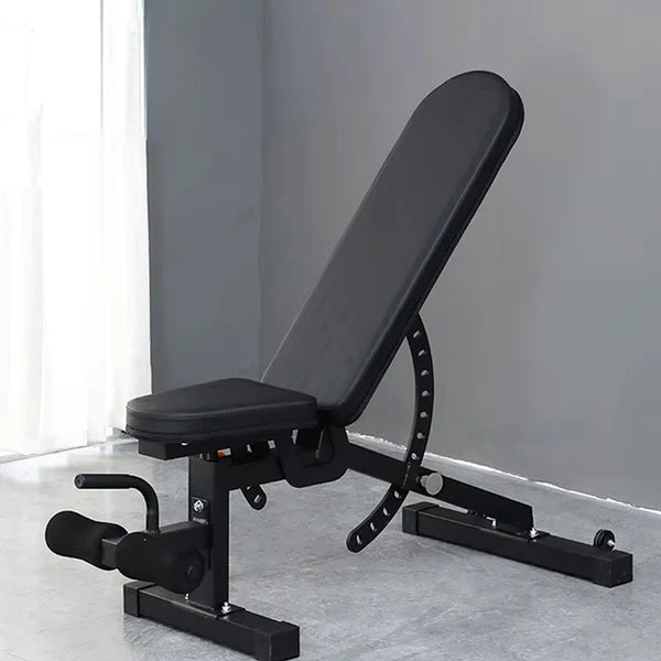 Black adjustable weight bench on a gray floor with a neutral background