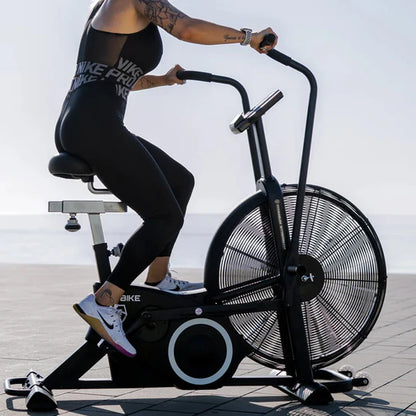 Person using an exercise bike outdoors with a blurred background