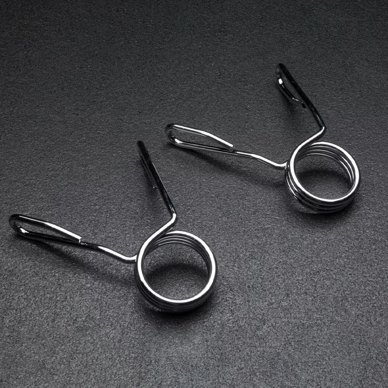 Two metal spring-loaded fishing line holders on a dark gray background