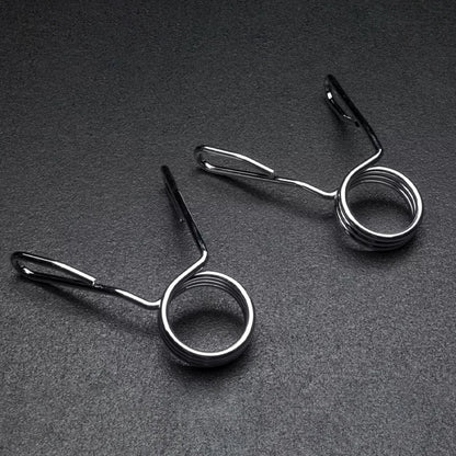 Two metal spring-loaded fishing line holders on a dark gray background