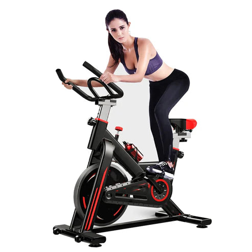 Woman exercising on a stationary bike against a white background