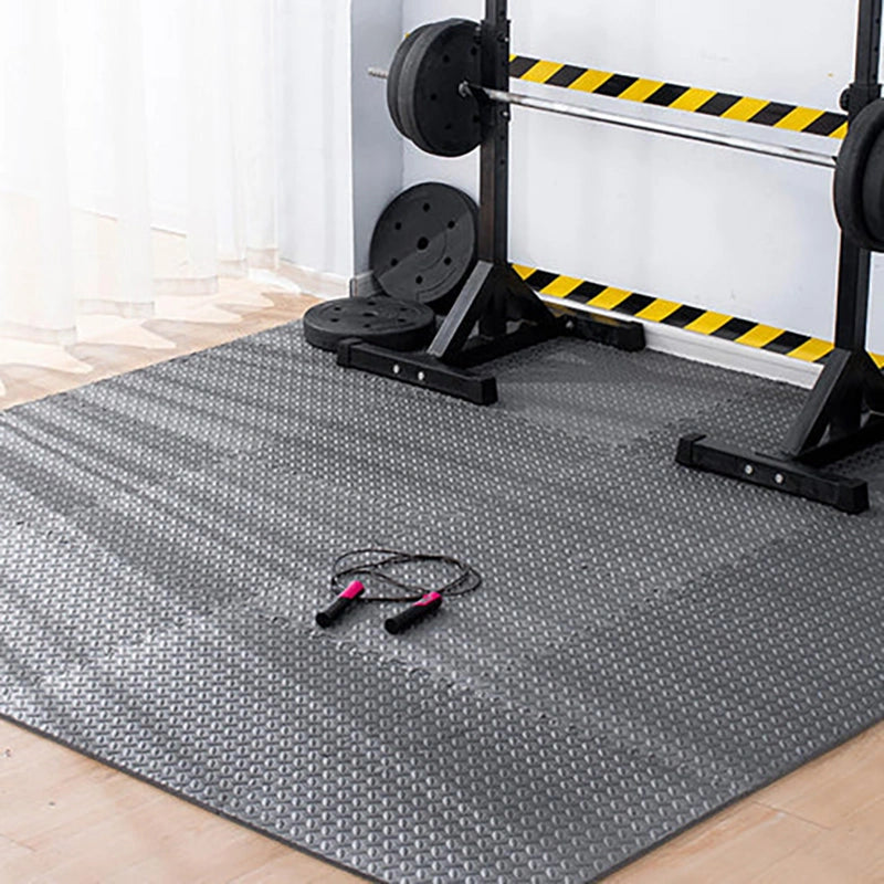 Gym floor mat with weightlifting equipment in the background
