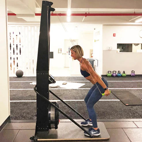 Woman exercising on a cable machine in a gym setting